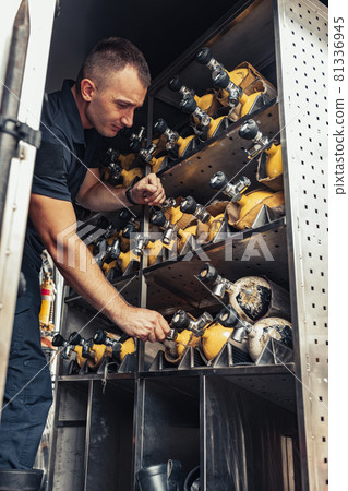 Fireman checking fire extinguisher in truck Fireman checking fire extinguisher in truck 81336945