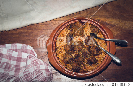 Dish of spaghetti and meatballs on a wooden table 81338360