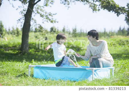 Parents and children playing in the garden pool 81339213