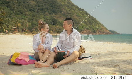 The cheerful love couple holding and eating slices of watermelon on tropical sand beach sea. Romantic lovers two people spend summer weekend. 81339563