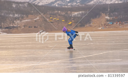 The girl train on ice speed skating. The child skates in the winter in blue sportswear suit, sport glasses. Children speed skating sport. 81339597
