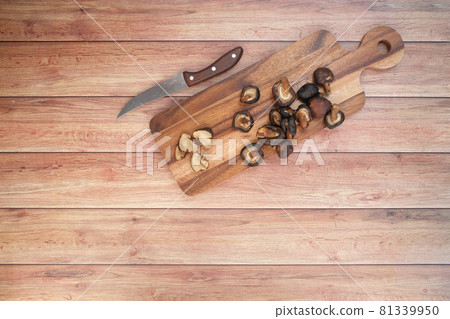 raw champignon mushroom ion a chopping board on table  81339950