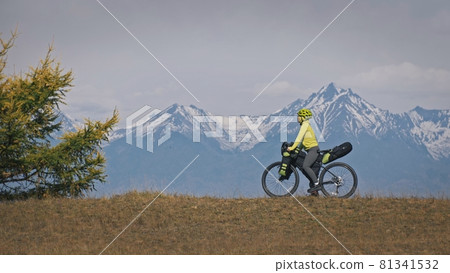 The woman travel on mixed terrain cycle touring with bikepacking. The traveler journey with bicycle bags. Sport tourism bikepacking. The woman travel on mixed terrain cycle touring with bikepacking. The traveler journey with bicycle bags. Sport tourism bikepacking. 81341532