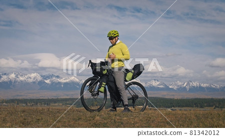 The man travel on mixed terrain cycle touring with bikepacking. The traveler journey with bicycle bags. Sport tourism bikepacking. The man travel on mixed terrain cycle touring with bikepacking. The traveler journey with bicycle bags. Sport tourism bikepacking. 81342012