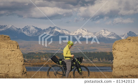 The man travel on mixed terrain cycle touring with bikepacking. The traveler journey with bicycle bags. Sport tourism bikepacking. The man travel on mixed terrain cycle touring with bikepacking. The traveler journey with bicycle bags. Sport tourism bikepacking. 81342013