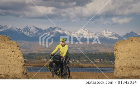 The man travel on mixed terrain cycle touring with bikepacking. The traveler journey with bicycle bags. Sport tourism bikepacking. The man travel on mixed terrain cycle touring with bikepacking. The traveler journey with bicycle bags. Sport tourism bikepacking. 81342014