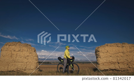 The man travel on mixed terrain cycle touring with bikepacking. The traveler journey with bicycle bags. Sport tourism bikepacking. The man travel on mixed terrain cycle touring with bikepacking. The traveler journey with bicycle bags. Sport tourism bikepacking. 81342017