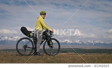 The man travel on mixed terrain cycle touring with bikepacking. The traveler journey with bicycle bags. Sport tourism bikepacking. The man travel on mixed terrain cycle touring with bikepacking. The traveler journey with bicycle bags. Sport tourism bikepacking. 81342025