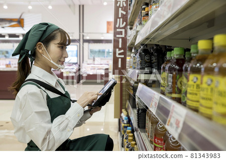 一位帶有鼠標護罩的女員工，在超市管理庫存 81343983