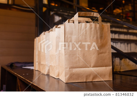 Courier delivery food service at home. Woman courier delivered the order no name bag with food. Courier delivery food service at home. Woman courier delivered the order no name bag with food. 81346832