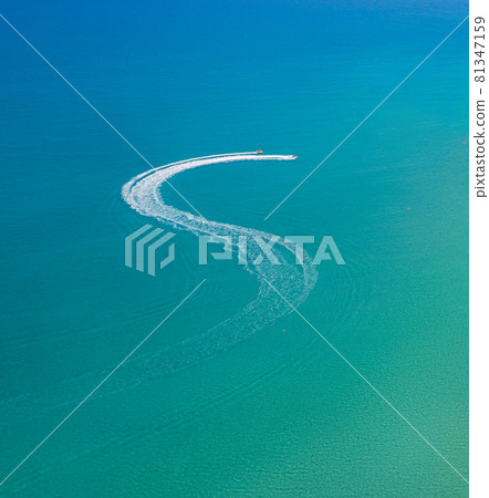 Watersports at the beach. Speedboat and wave slider leaving zigzag trail on water, aerial view 81347159