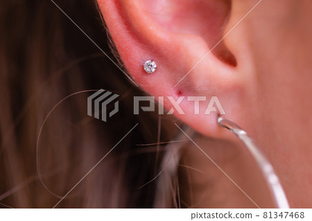 Professional holding the jewel of piercing just before screw the ball. Professional holding the jewel of piercing just before screw the ball. 81347468