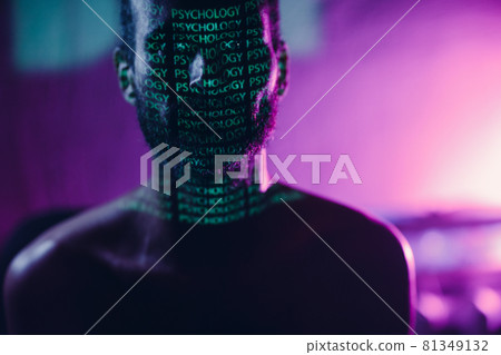Young adult man with word Psychology on his face in the dark. Young adult man with word Psychology on his face in the dark. 81349132