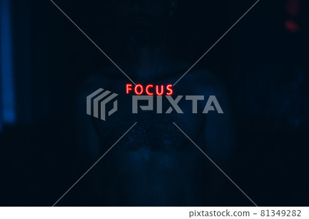 Young man with letters ad Focus word on his face in the dark. Young man with letters ad Focus word on his face in the dark. 81349282