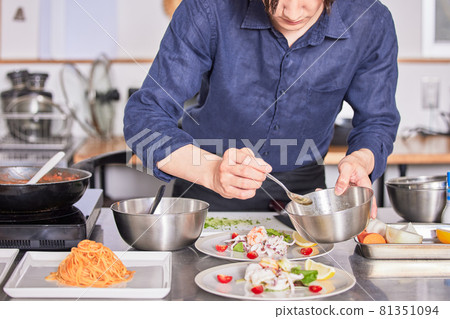Young man in an apron with sauce on salad, cooking boy image 81351094