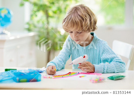 Crafts for kids. Child with hot glue gun. 81353144