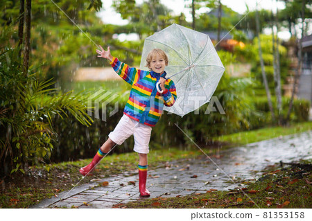 Child playing in autumn rain. Kid with umbrella. Child playing in autumn rain. Kid with umbrella. 81353158