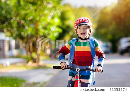 Boy going to school on bike. Kids ride bicycle. 81353274