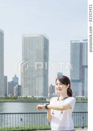 A woman checking her health with a smart watch while walking A woman checking her health with a smart watch while walking 81353451