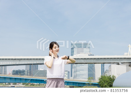 A woman checking her health with a smart watch while walking A woman checking her health with a smart watch while walking 81353756