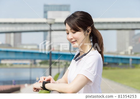 A woman checking her health with a smart watch 81354253