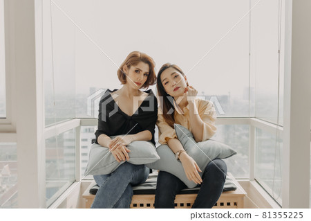 Cool looking women friends having photoshoot in their apartment. 81355225