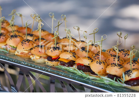 Mini burgers with black sesame seeds at a buffet table Mini burgers with black sesame seeds at a buffet table 81355228