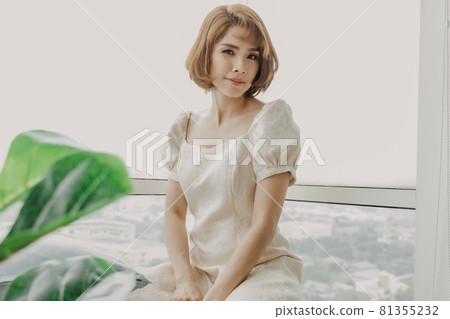 Soft and sweet looking Asian woman wears white dress. 81355232