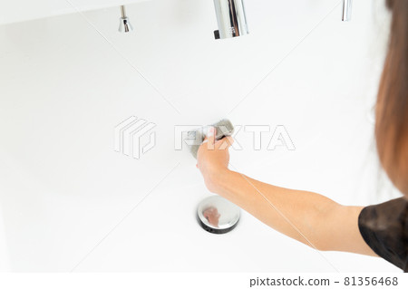 Girl cleaning the washbasin Girl cleaning the washbasin 81356468