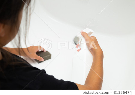Girl cleaning the washbasin Girl cleaning the washbasin 81356474