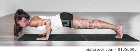 Yoga woman training pushup plank chaturanga dandasana banner. Yoga pose girl doing pushups arms and core exercise. Panoramic crop 81356696