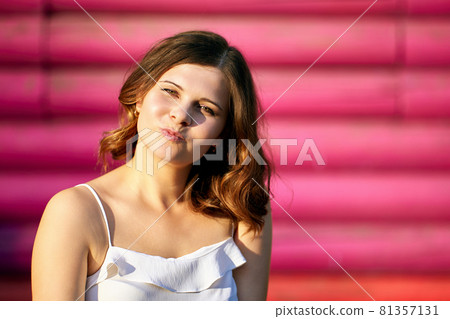 European happy woman sits outdoors near building. European happy woman sits outdoors near building. 81357131