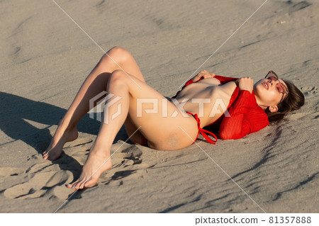 Feminine young sexy woman relaxing on sandy shore 81357888