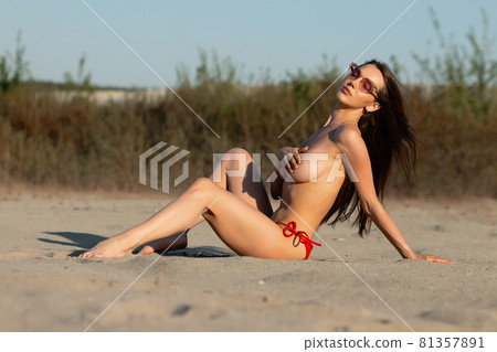 Feminine young sexy woman relaxing on sandy shore 81357891