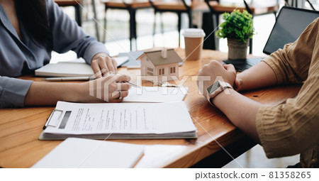 Real estate agent or bank officer describes the loan interest to the customer with home purchase contracts or on office loans and interest rates 81358265