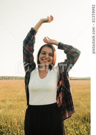 a happy girl with long black hair in a wheat field. He enjoys the happy moments of his life. 81359992