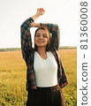a happy girl with long black hair in a wheat field. He enjoys the happy moments of his life. 81360008