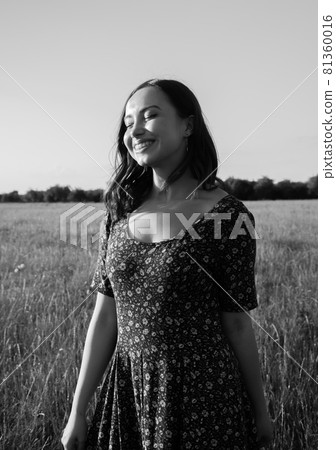 a happy girl with long black hair in a wheat field. He enjoys the happy moments of his life. 81360016