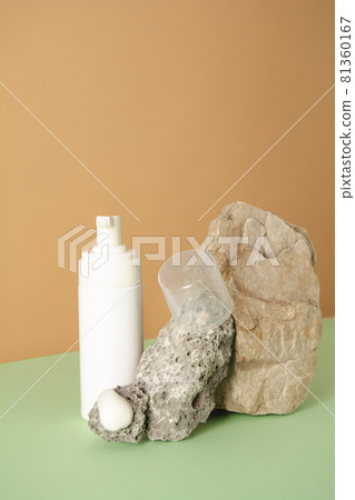 Cosmetic bottle and facial product sample on a stone. Copy space 81360167