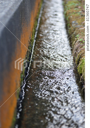 Water flowing through the gutter Water flowing through the gutter 81360747