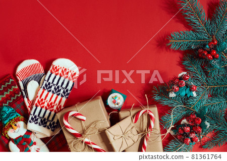 Christmas composition of pine cones, spruce branches and stack of gift boxes on red background 81361764