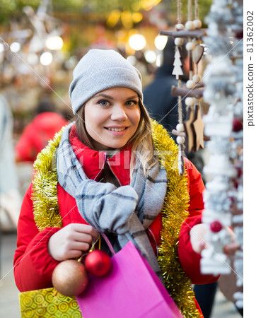 Portrait of young girl choosing xmas gifts on the street market 81362002