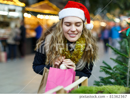 Woman holding bags with Christmas toys 81362367