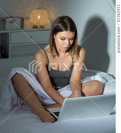 Portrait of sexy positive woman sitting with laptop in bed Portrait of sexy positive woman sitting with laptop in bed 81362451