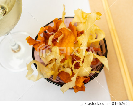 Crispy chips of sweet potatoes and cassava served with wine Crispy chips of sweet potatoes and cassava served with wine 81362601