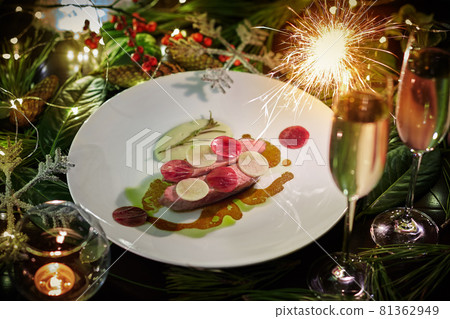 Baked duck breast with daikon, beetroot, bechamel sauce on background of new year decorations 81362949