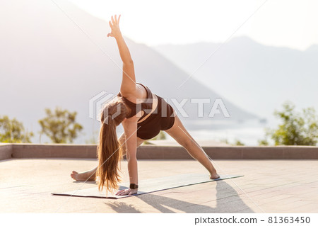Young woman doing wild thing yoga pose outdoors in the morning 81363450