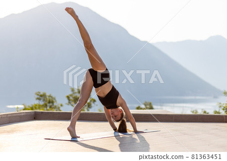 Young woman doing vinyasa yoga routine in the morning at the resort pool 81363451