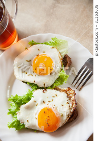 Toasts with fried eggs near hot tea 81363638