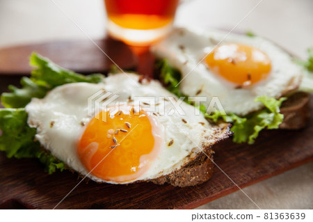 Toasts with fried eggs near hot tea Toasts with fried eggs near hot tea 81363639